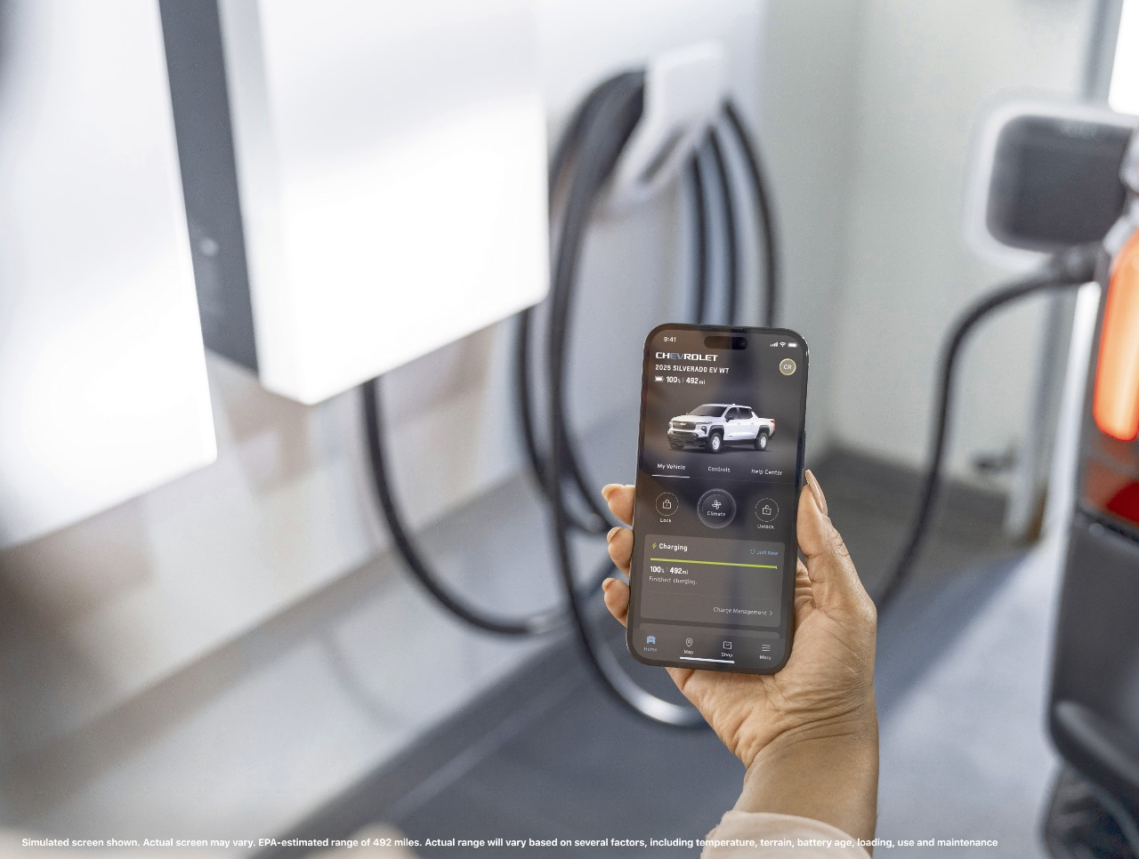 A smartphone showing the 2025 Silverado EV WT’s range of 492 miles on the myChevy app.