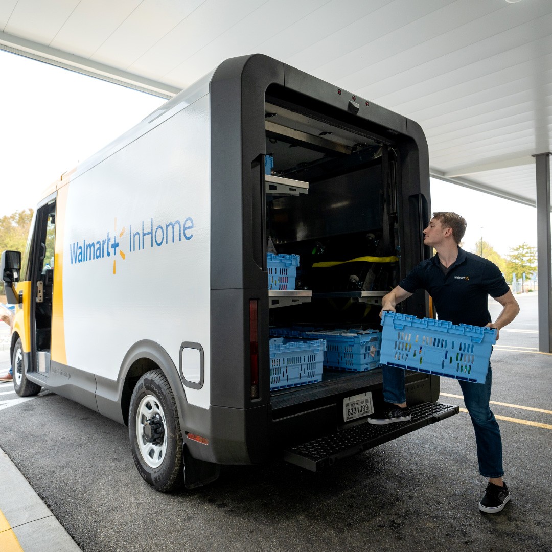 A Walmart InHome Associate loads crates into a Chevrolet BrightDrop 400 electric van