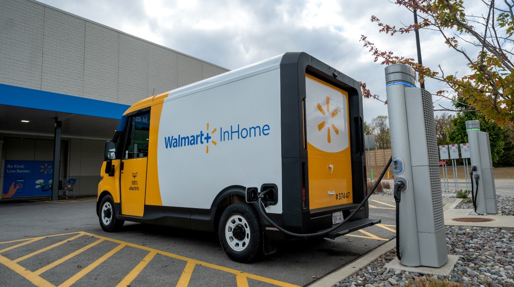 A Walmart InHome Associate loads crates into a Chevrolet BrightDrop 400 electric van