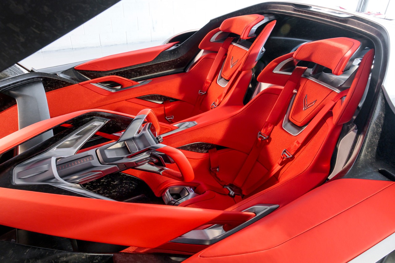 The interior and bucket seats of a silver convertible sports car.