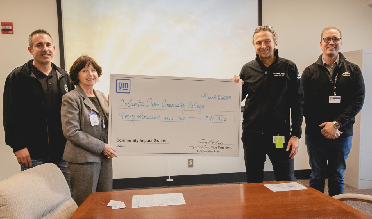 General Motors Employees holding AACC Grant Check.