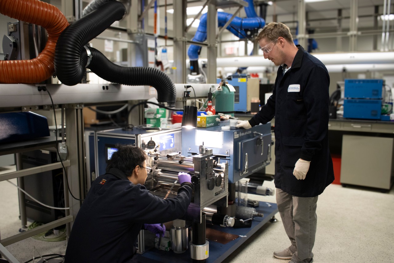 Man holding a child while wake surfing on a lake.