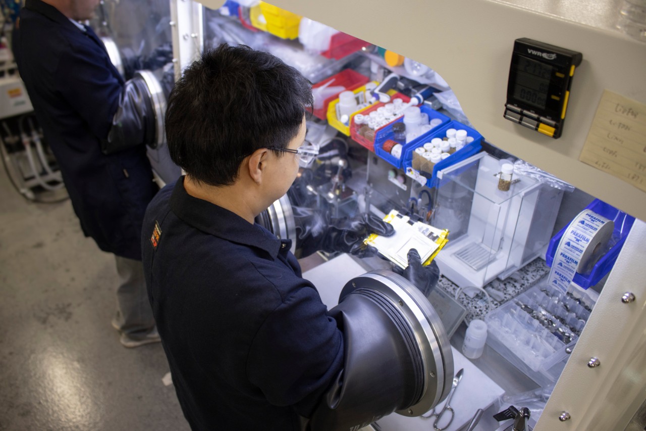 Man holding a child while wake surfing on a lake.