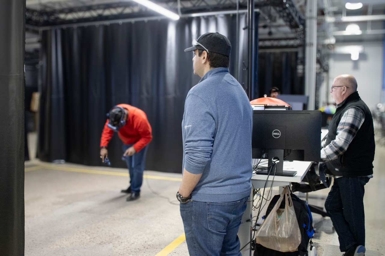 Max Sikorski, in a blue quarter-zip, jeans and a black baseball, and VR Specialist Kevin LaPrise, in a plaid shirt and vest