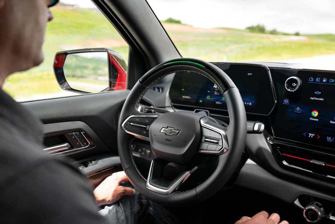 A Cadillac LYRIQ behind an EF Pro Cycling rider.