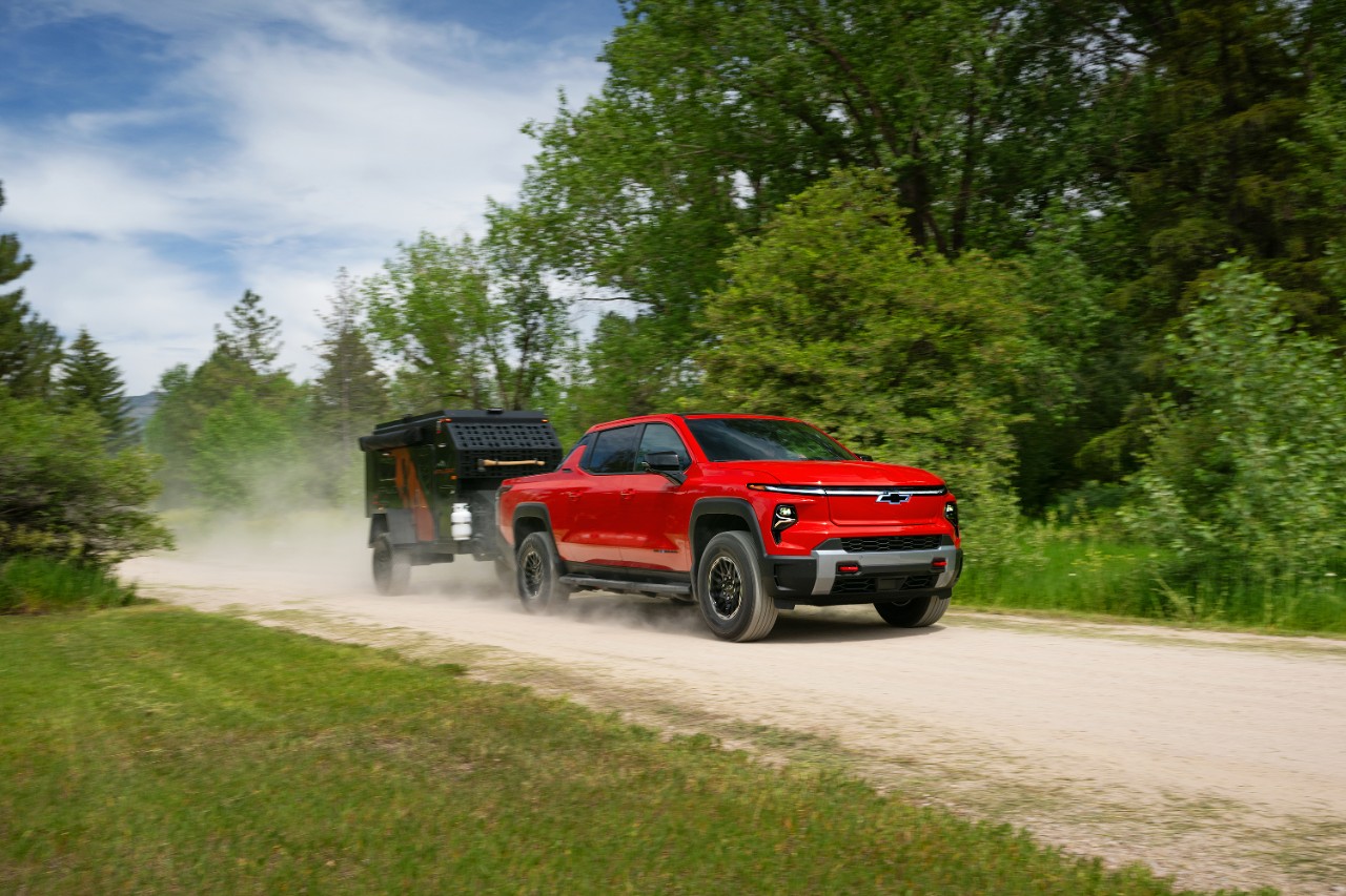 A Cadillac LYRIQ behind an EF Pro Cycling rider.