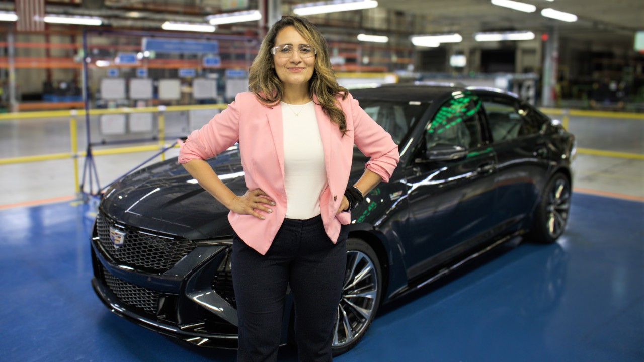 Woman standing in front of a parked car.