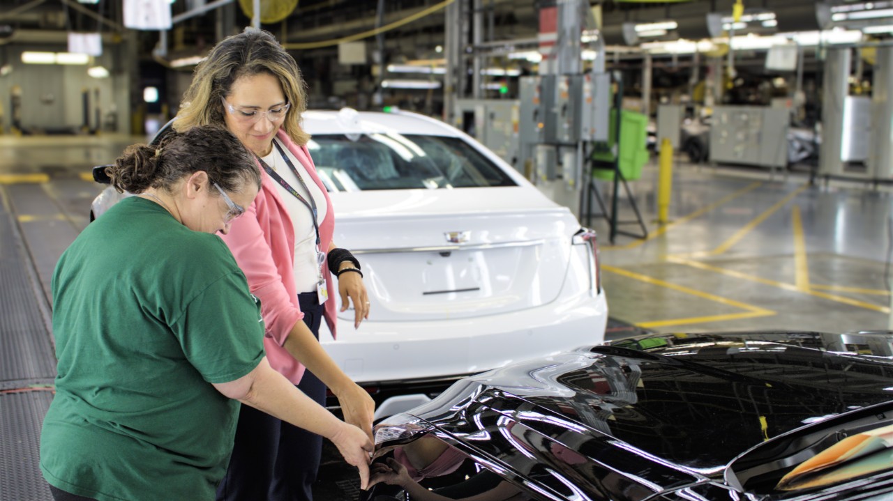 April Rios on the job assisting quality checks. Two woman looking at a vehicle.