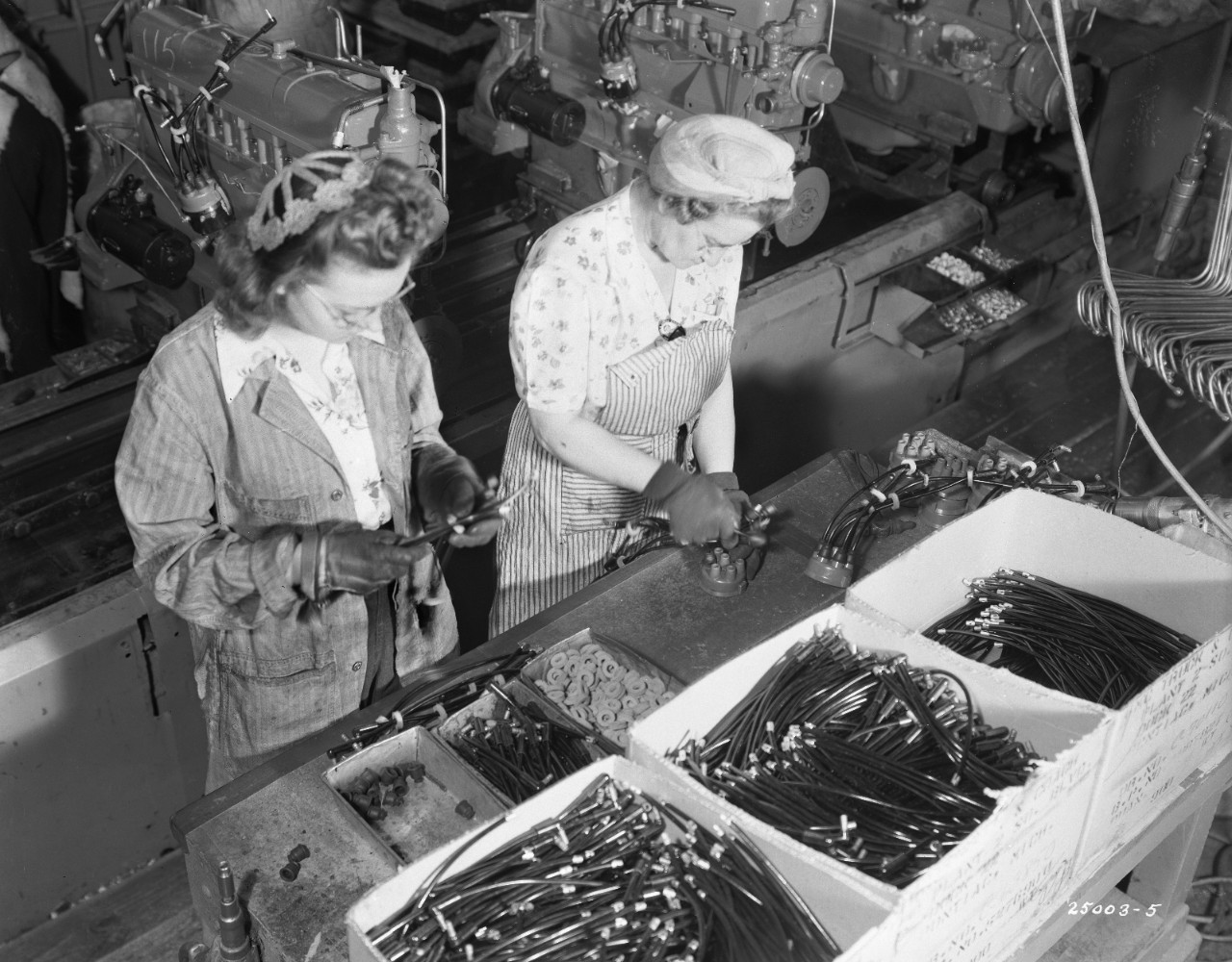 Black-and-white photo of a woman working in a factory.