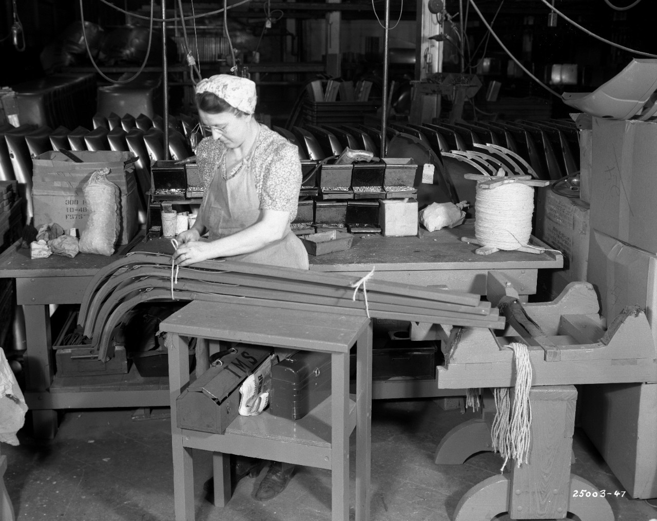Black-and-white photo of a woman working in a factory.