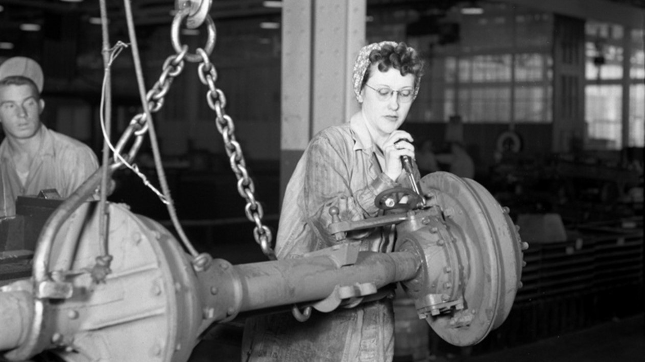 Black-and-white photo of a woman working on a machine