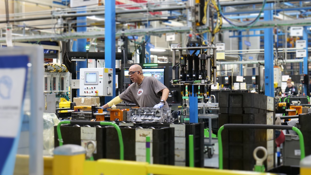 A man building an engine in a plant.