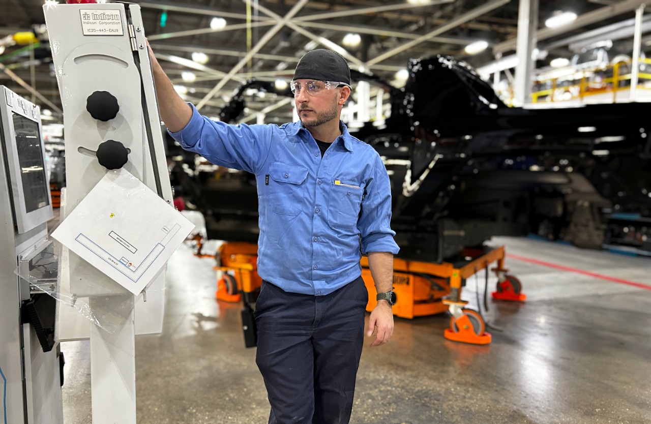 A man works on equipment on an assembly line.