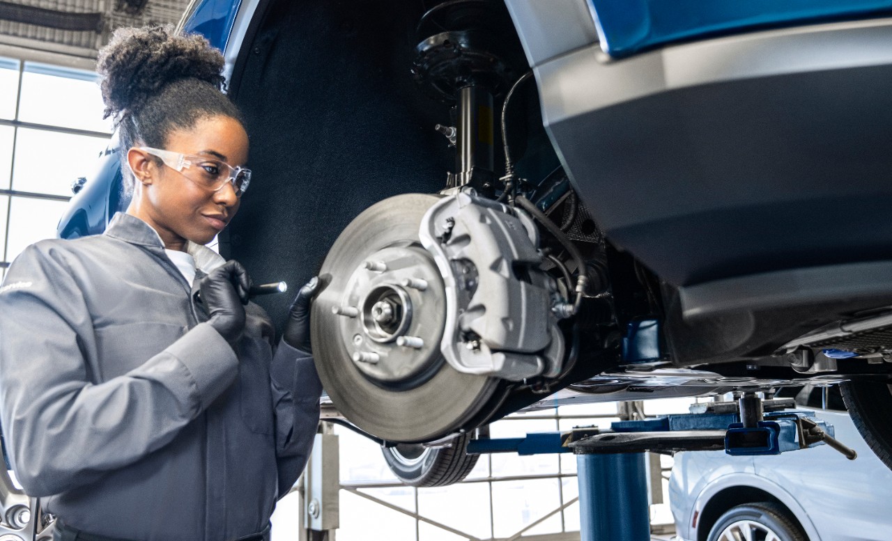 A technician working on brakes on a GM vehicle.