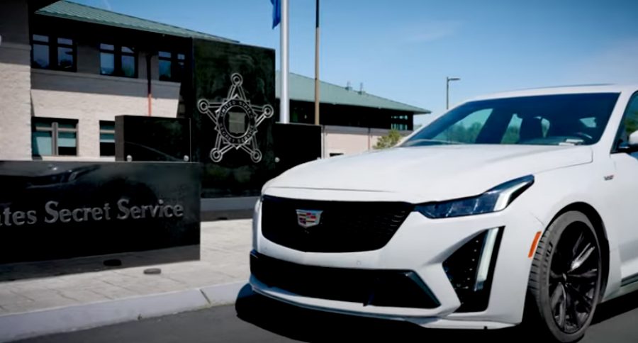 A Cadillac in front of a Secret Service sign.
