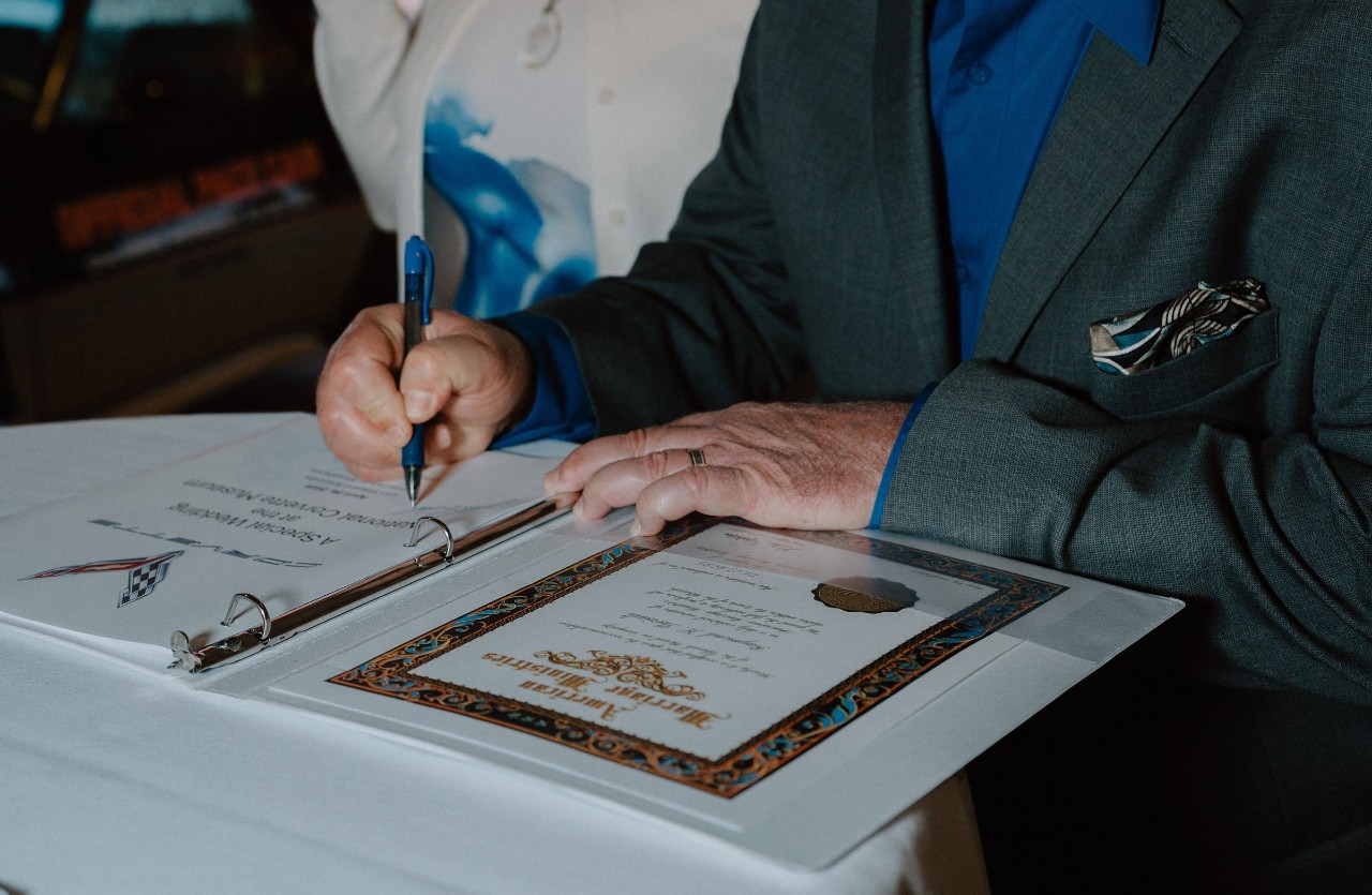 A man signs a paper document.
