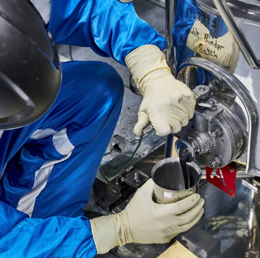 A GM battery technician takes a chemistry slurry sample. (Photo by Steve Fecht for General Motors)