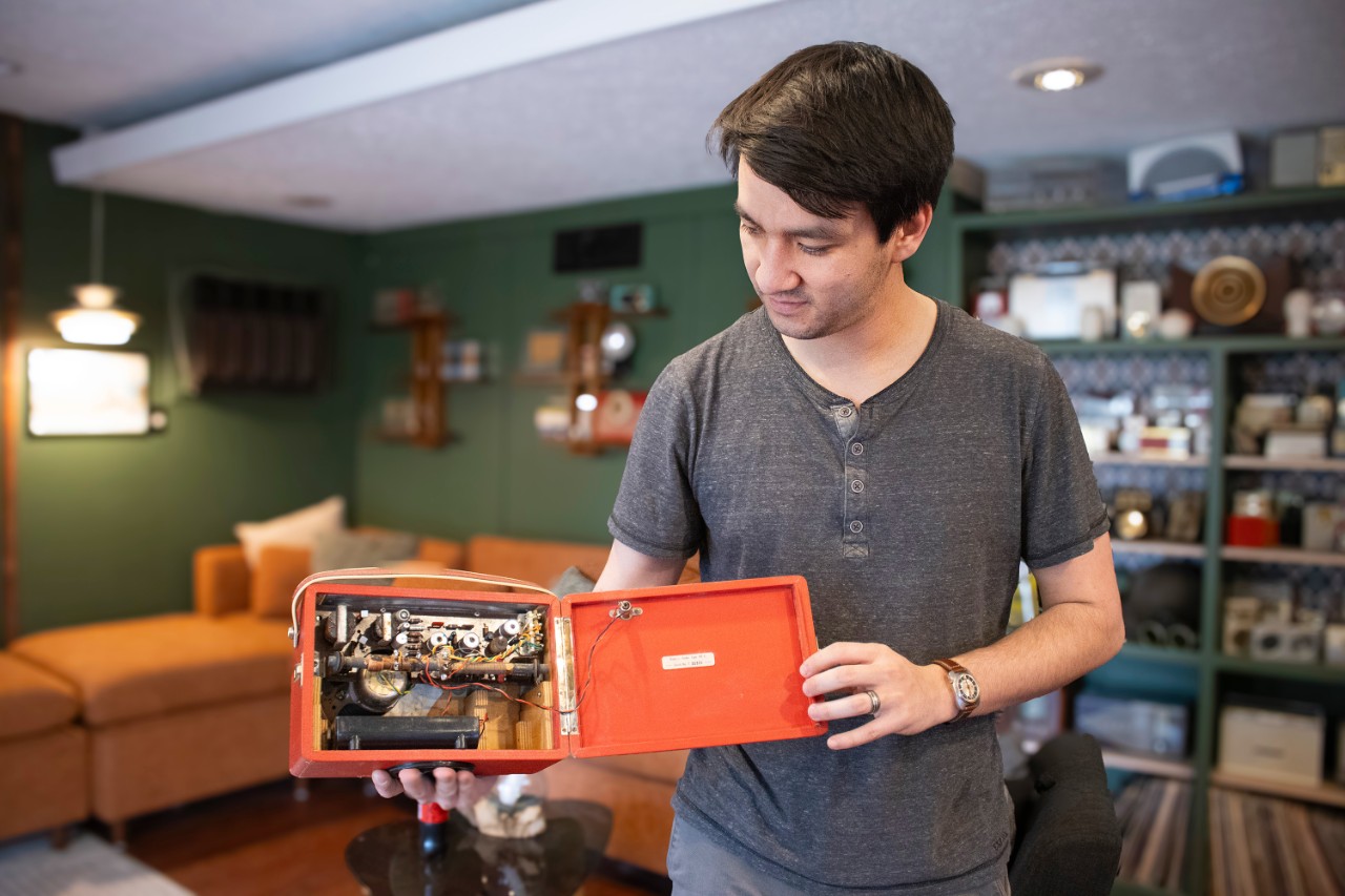 A man holding an orange radio.