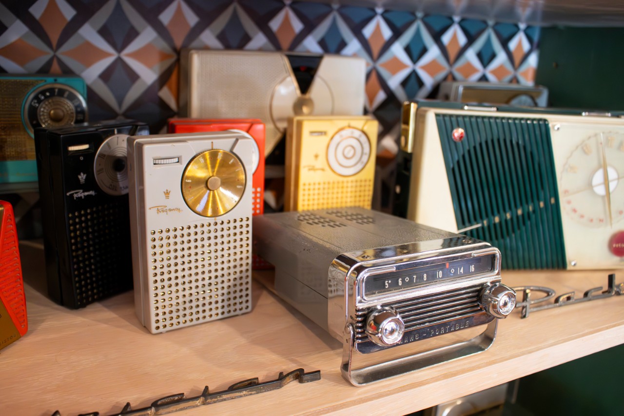 A collection of radios on a shelf.