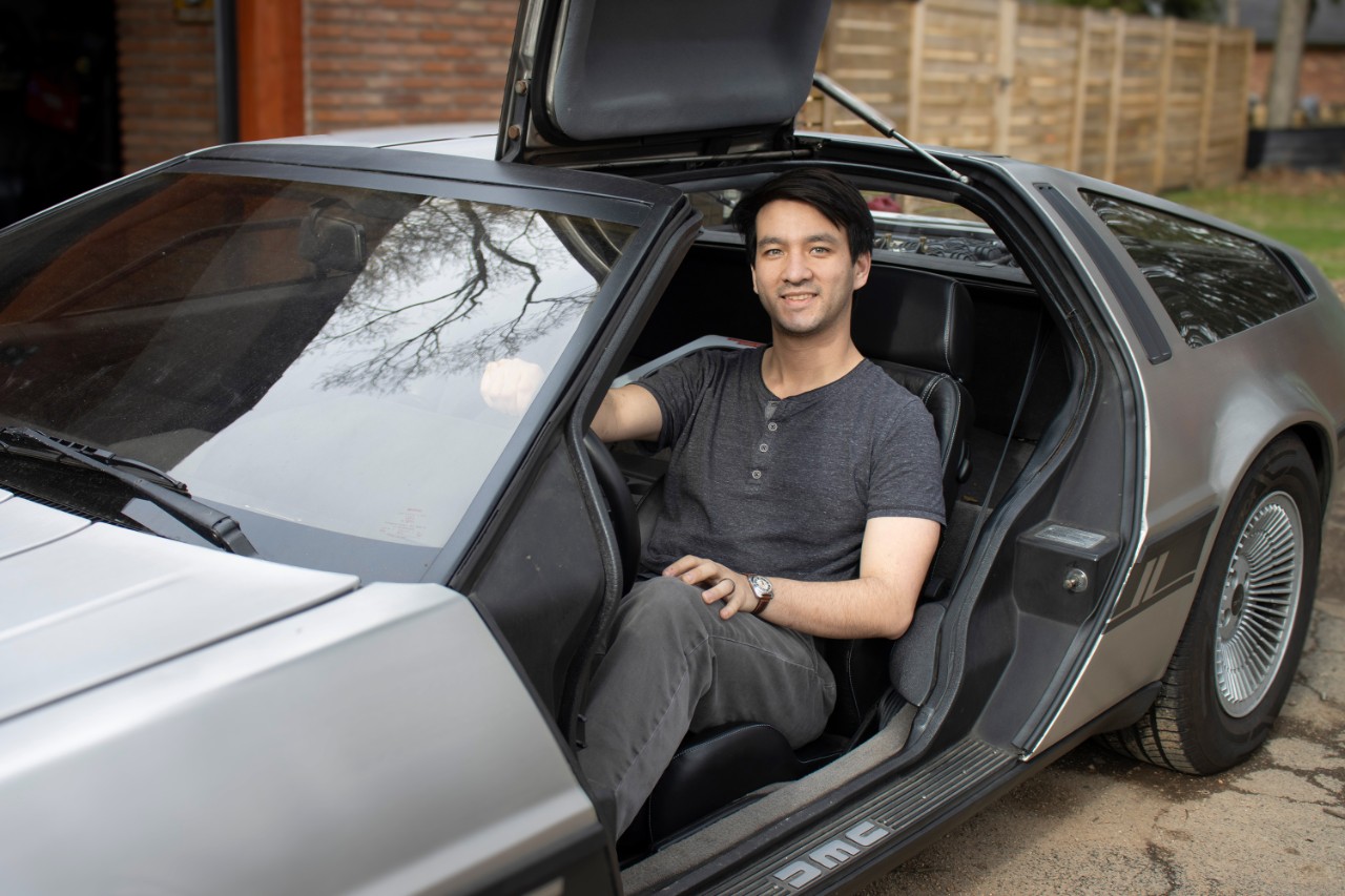 Jayce_Delker_DeLorean A man sitting in a silver car.