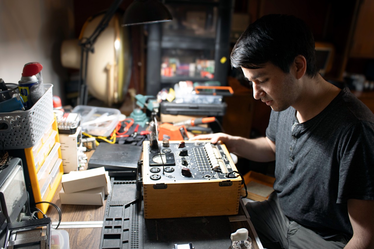 A man holding a pocket-sized radio.