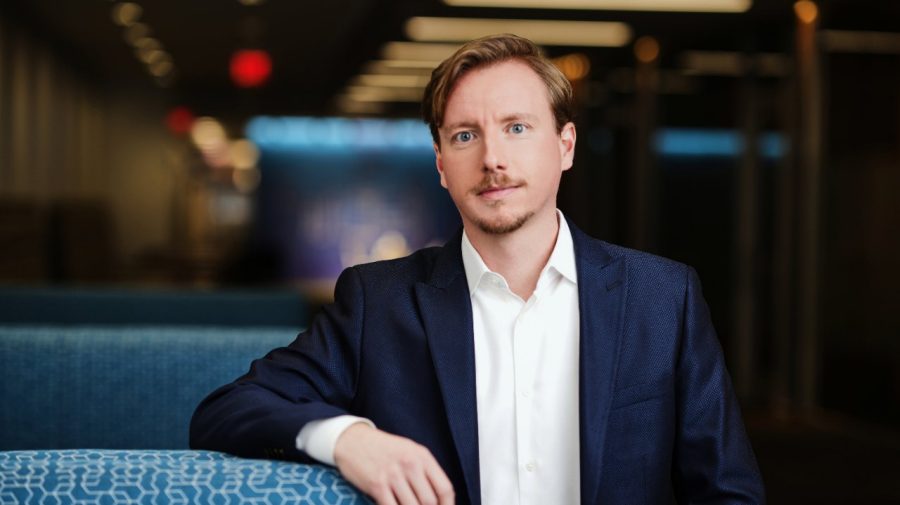A man posing in a hallway