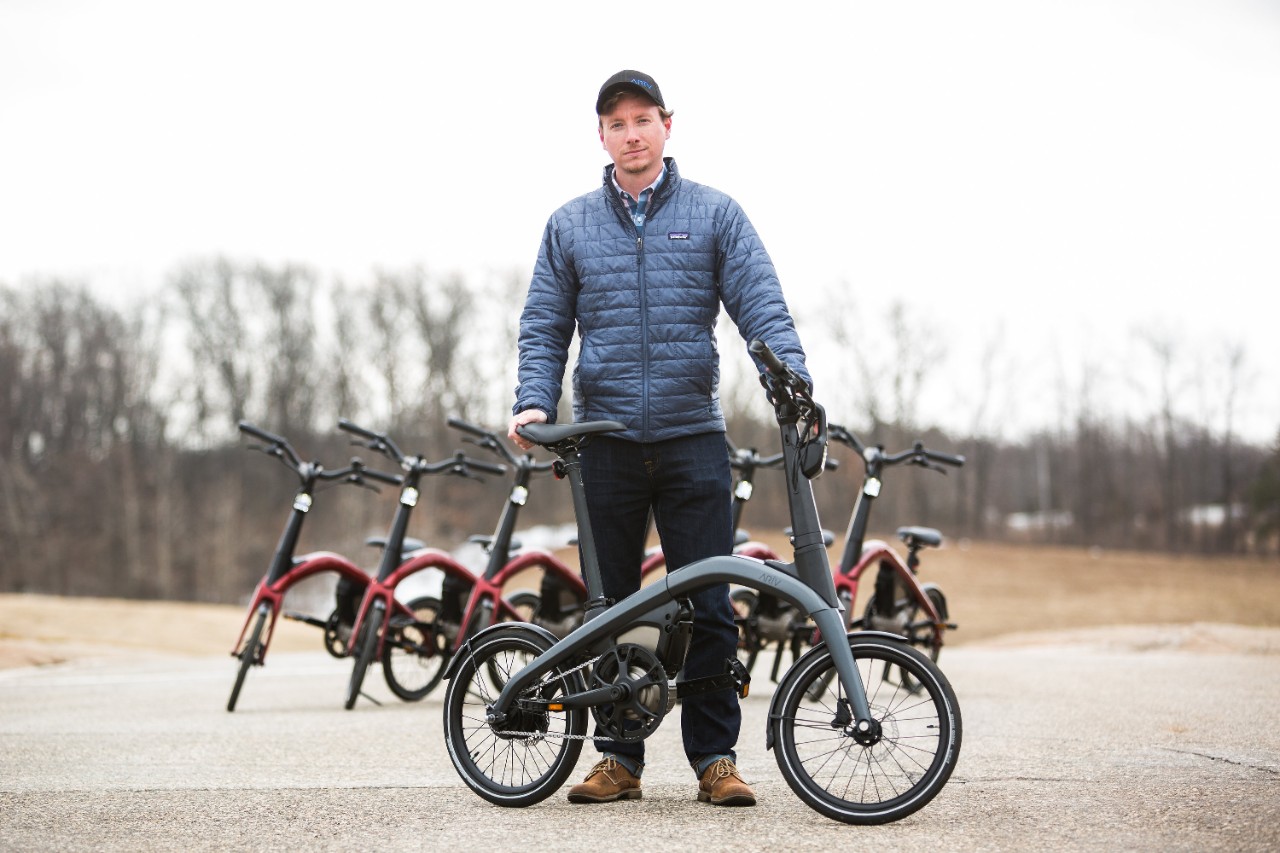A man standing in front of a bicycle
