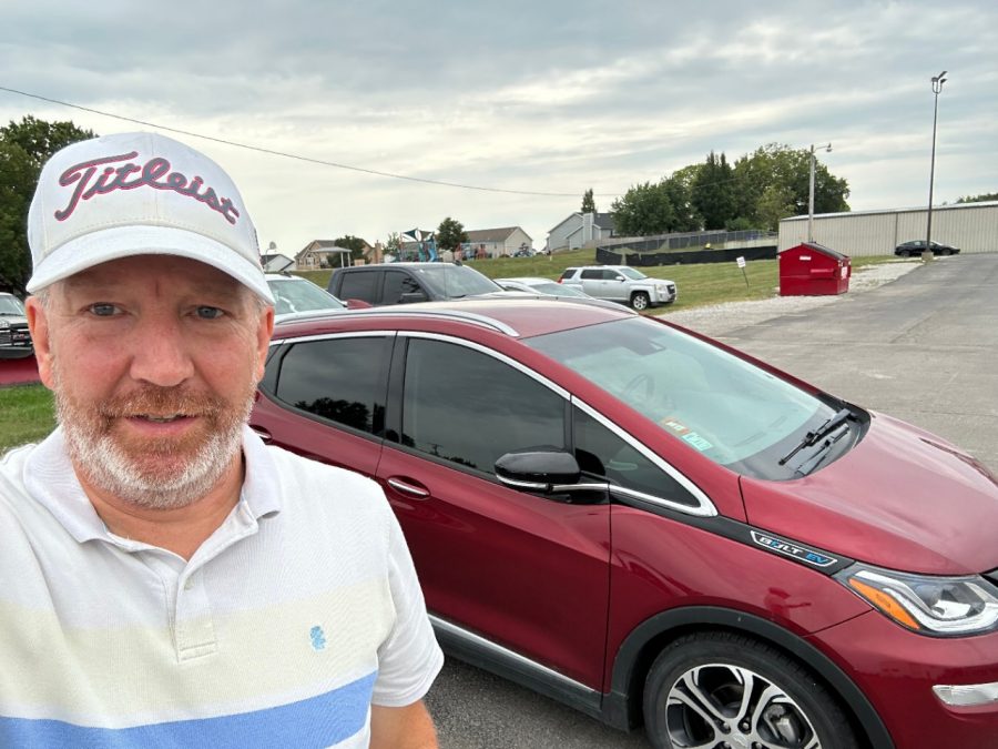 Man standing in front of red car