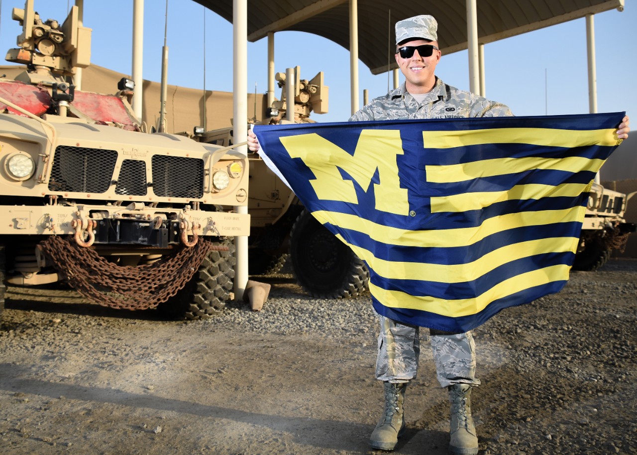 Brandon Gifford holding a University of Michigan flag.