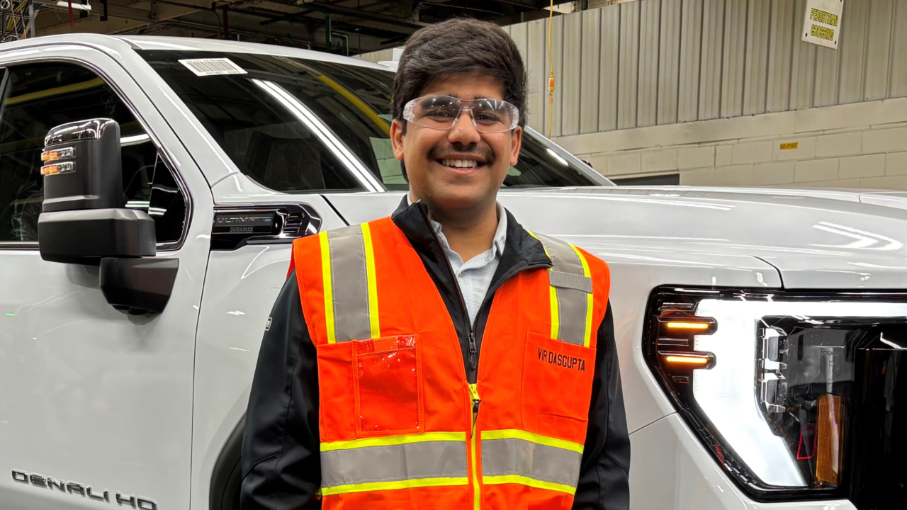 Vir poses next to a GMC Sierra Denali Heavy Duty at Flint Assembly. 