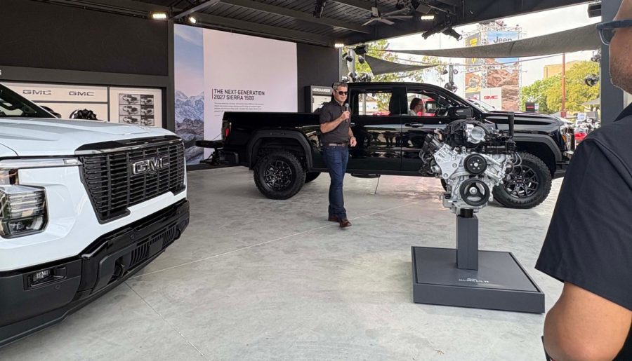 Black 2027 GMC Sierra with person speaking in front of it