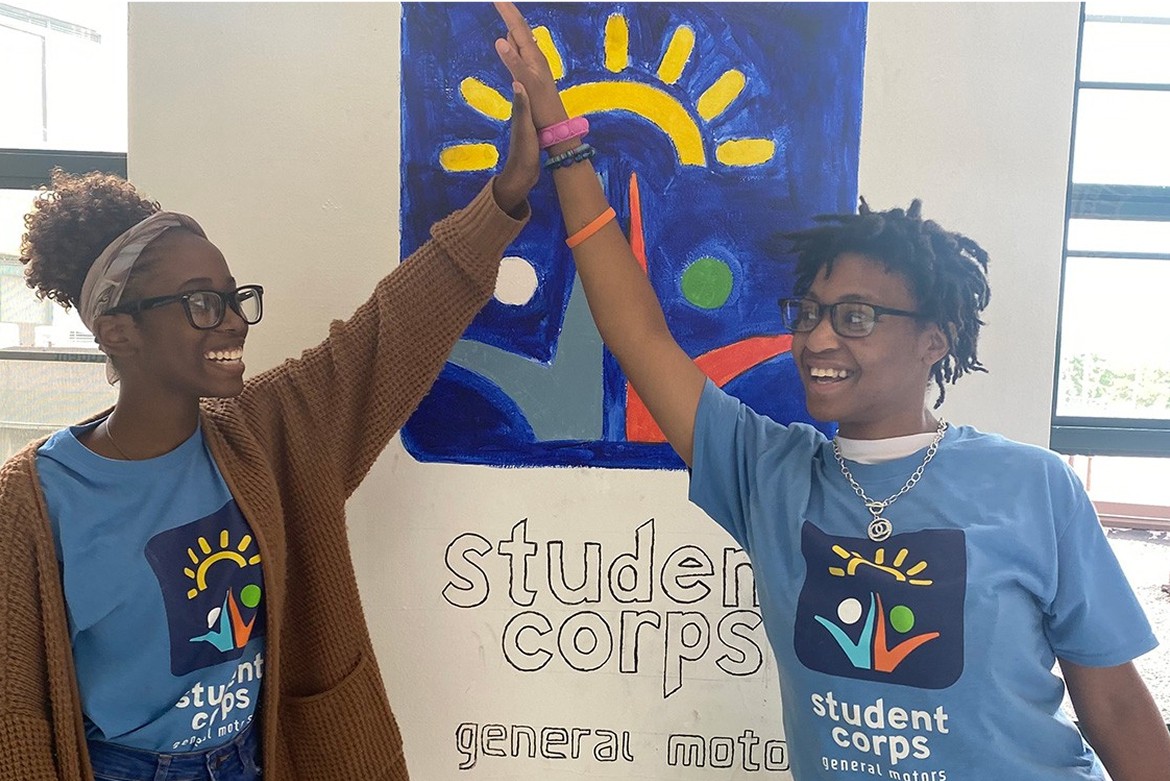 Two Happy High School Students Smiling and Giving Each Other a High Five