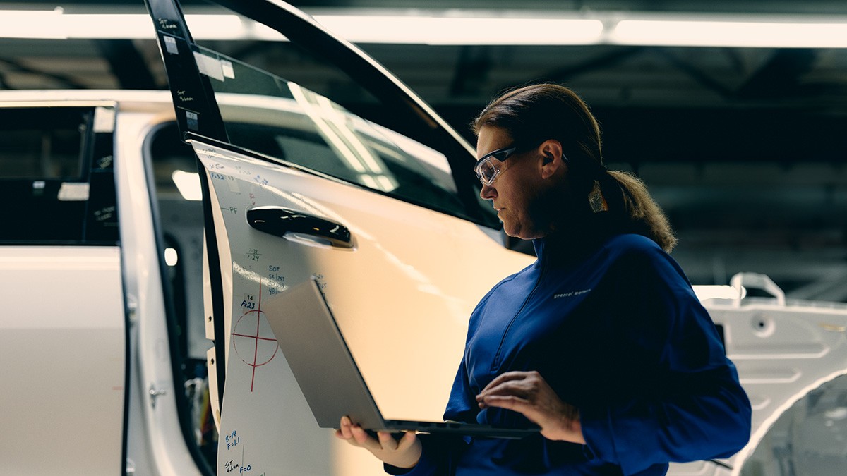Bird's Eye View of Long Winding Road In the Middle of a Forest of Trees Next to a Body of Water
