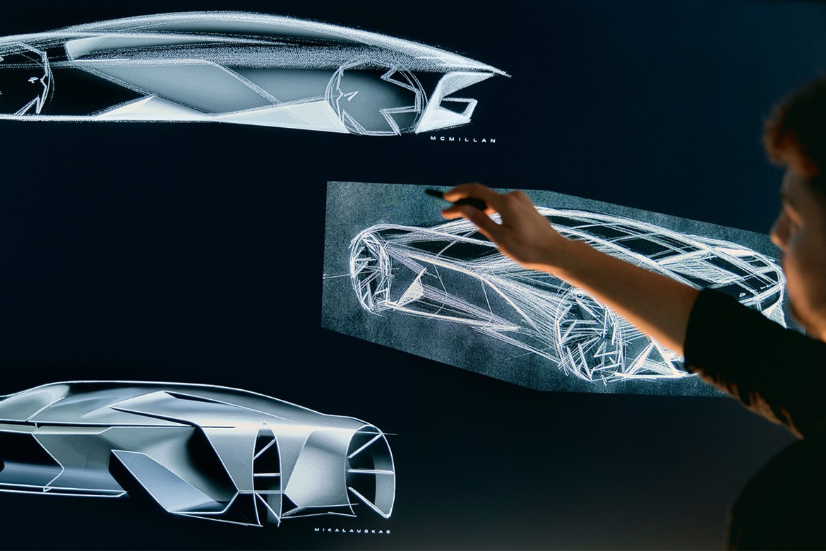 Close-up of a Man Pointing on a Drawing Board Displaying GM’s Concept Vehicle Designs 